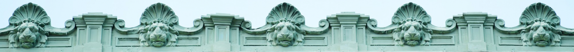 Banner image of stone lion gargoyles lining the top of a building on the Columbia campus.