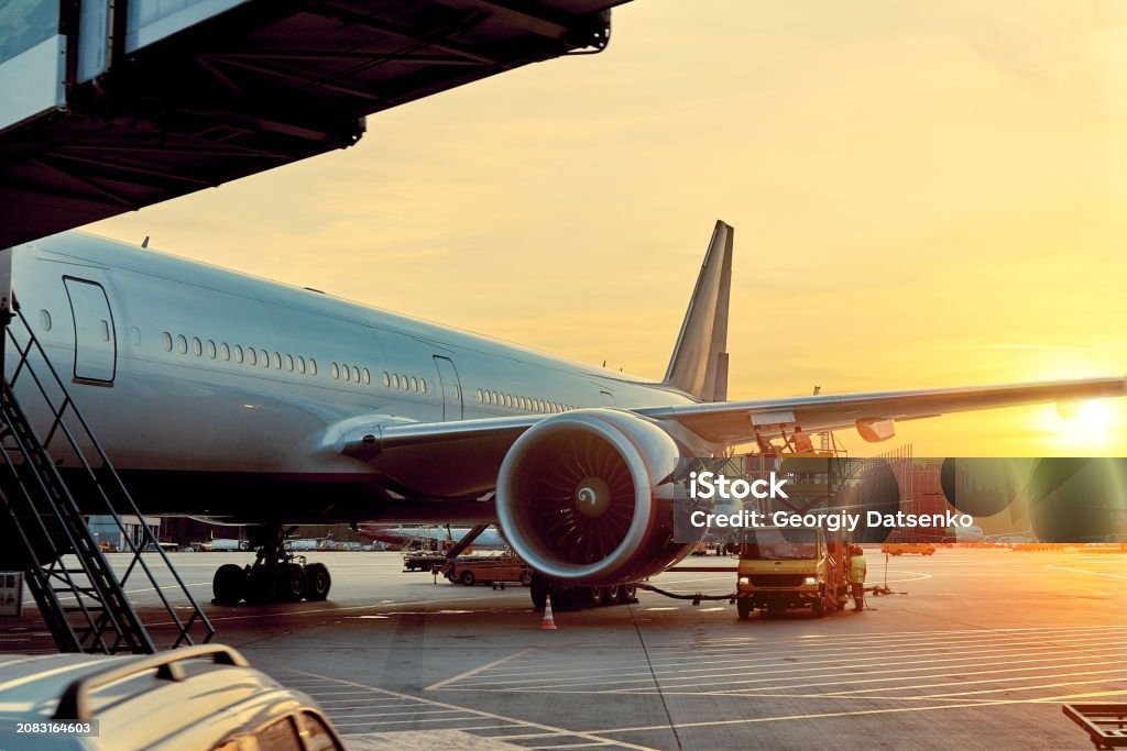 Airplane at the airport during sunset. 