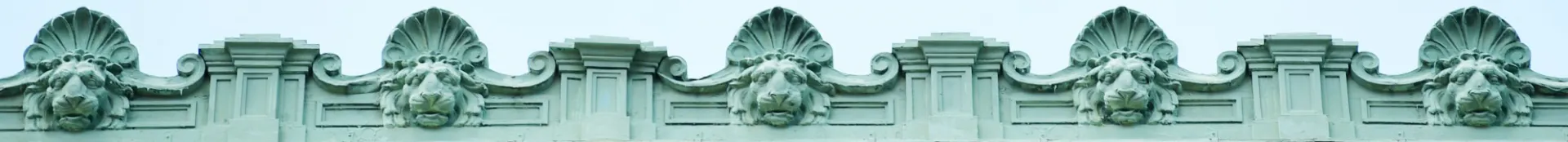 Banner image of stone lion gargoyles lining the top of a building on the Columbia campus.