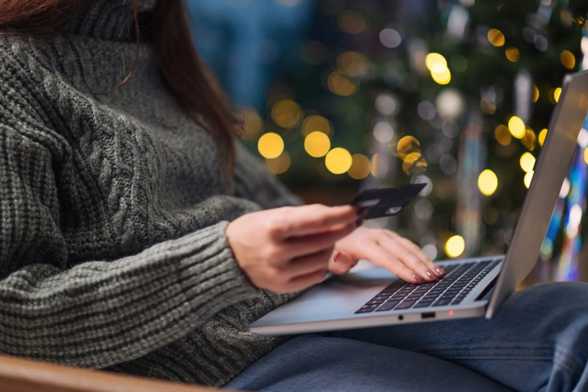 Woman using her credit card to purchase goods on a computer. 